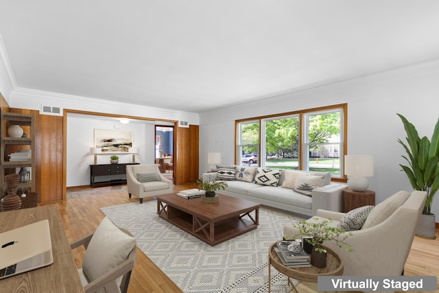 living room featuring visible vents, ornamental molding, and wood finished floors