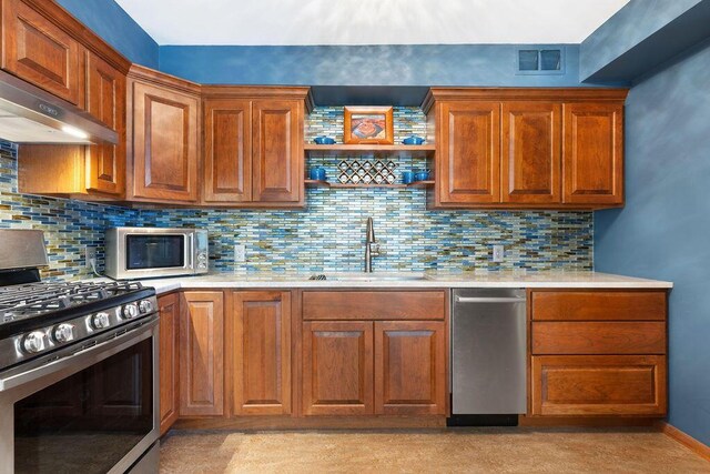 kitchen featuring a sink, light countertops, stainless steel appliances, under cabinet range hood, and visible vents