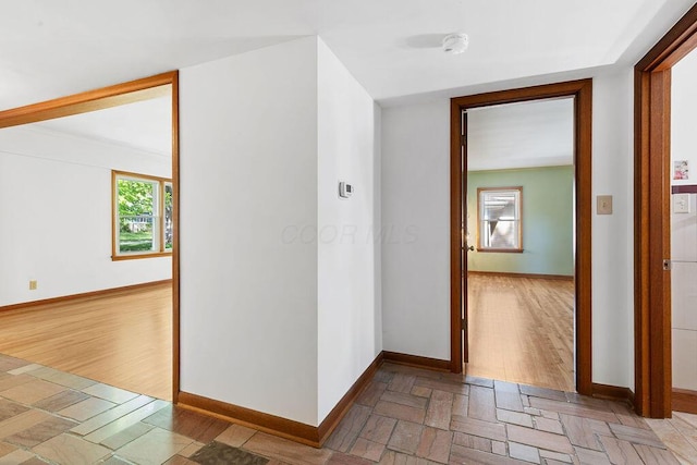 hall featuring baseboards and light wood-style flooring