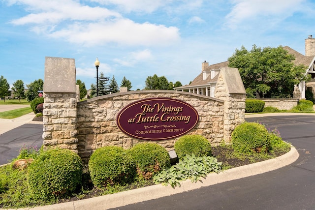 community / neighborhood sign featuring uncovered parking