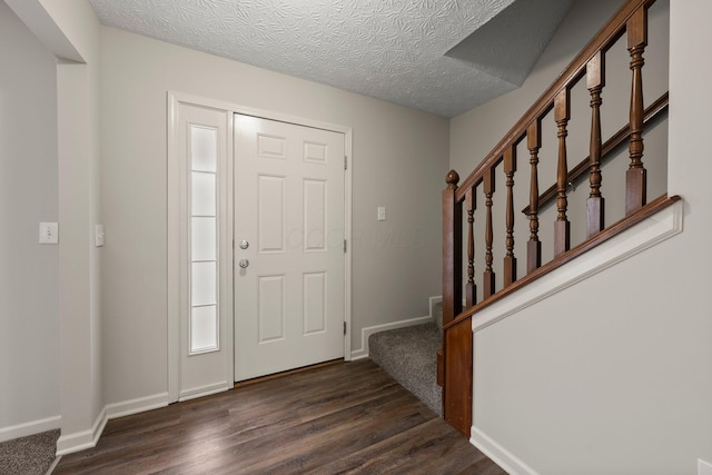 entryway with stairs, dark wood-style flooring, baseboards, and a textured ceiling