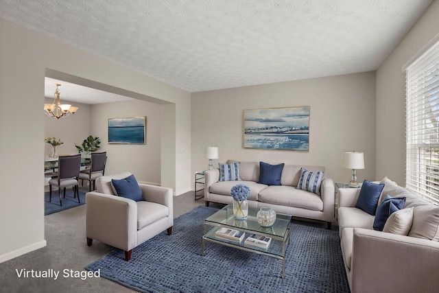 living room featuring a chandelier, carpet floors, baseboards, and a wealth of natural light