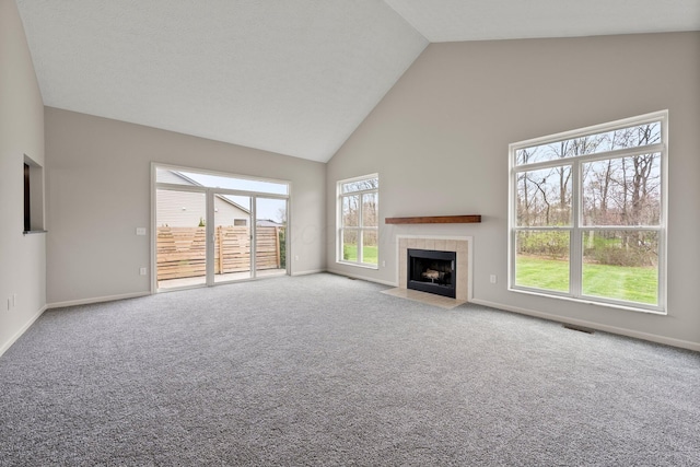 unfurnished living room with high vaulted ceiling, baseboards, carpet flooring, and visible vents