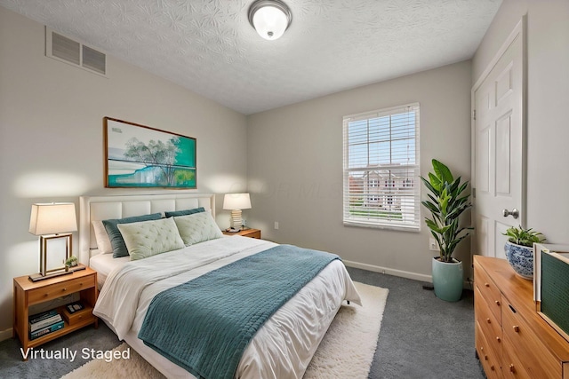 carpeted bedroom with a textured ceiling, baseboards, and visible vents