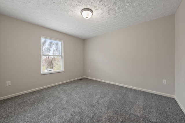 carpeted empty room with visible vents, baseboards, and a textured ceiling