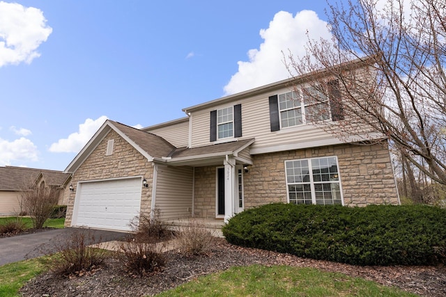 traditional-style house featuring an attached garage, aphalt driveway, and stone siding