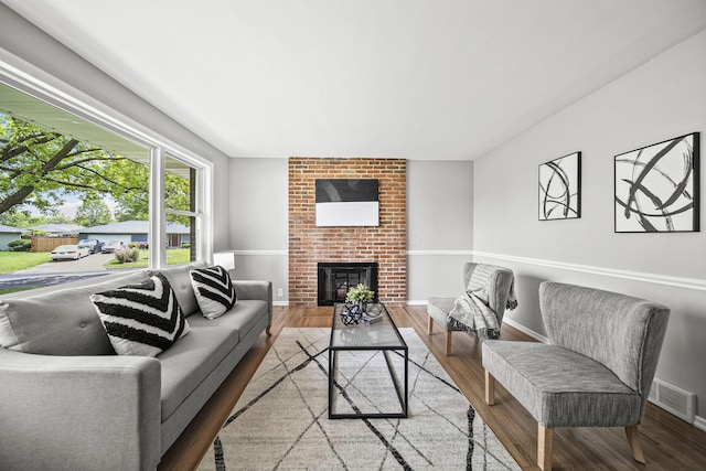 2960 Berwick Blvd, Columbus, OH 43209 - living room featuring wood finished floors, a brick fireplace, and baseboards
