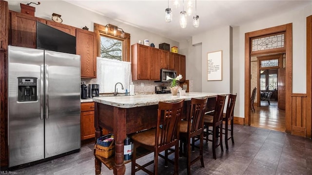 kitchen with appliances with stainless steel finishes, a sink, backsplash, and a wealth of natural light