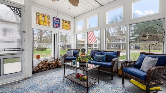 sunroom / solarium featuring an outdoor living space, finished concrete floors, and a ceiling fan