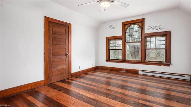 empty room featuring baseboards, hardwood / wood-style floors, a baseboard heating unit, and lofted ceiling