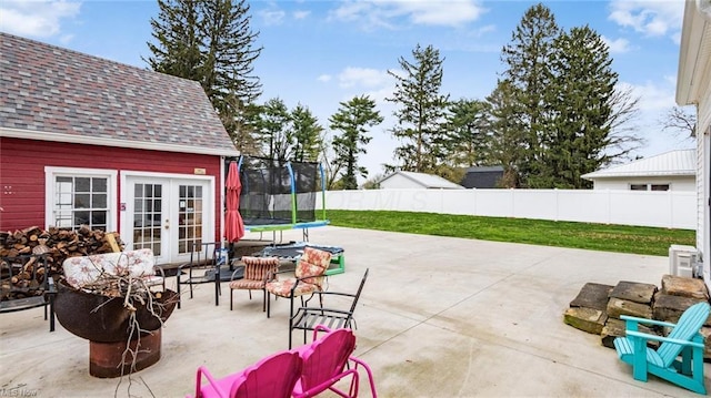 view of patio / terrace with french doors, a trampoline, and fence