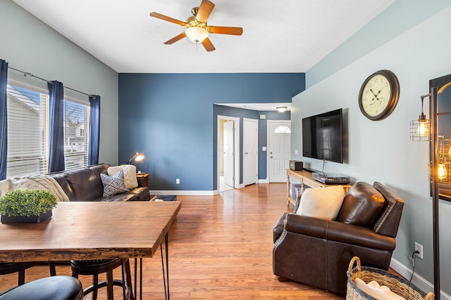 living room with a ceiling fan, baseboards, and light wood-style floors