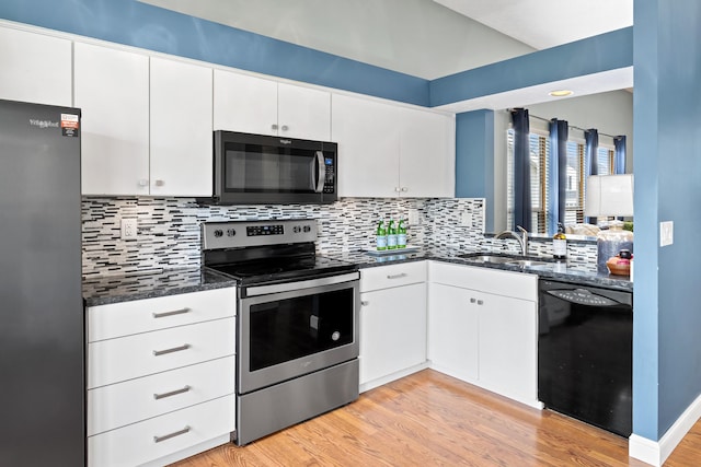 kitchen featuring white cabinets, stainless steel appliances, a sink, and backsplash