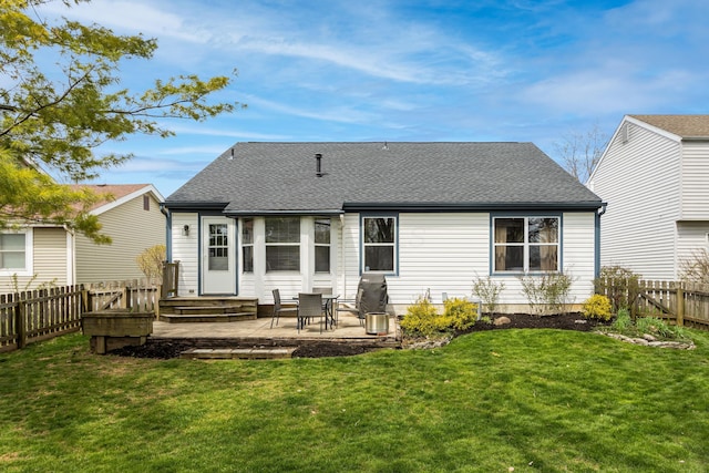 rear view of property featuring a fenced backyard, roof with shingles, a yard, and a patio