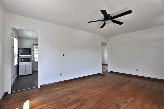 3113 Oaklawn St, Columbus, OH 43224 - spare room featuring dark wood finished floors, baseboards, and ceiling fan