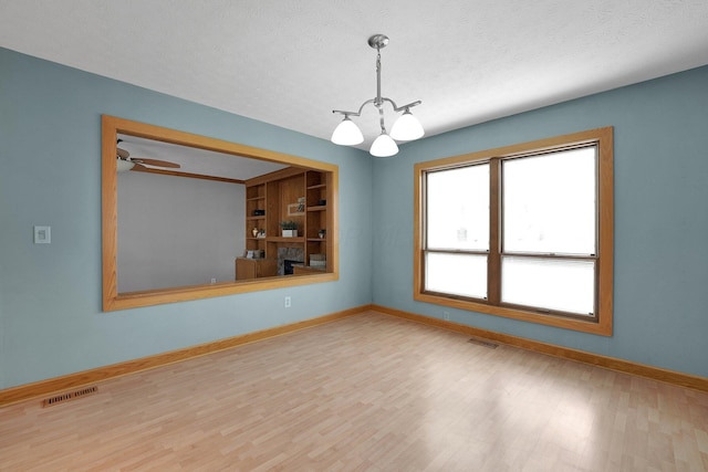 441 Gentlewind Dr, Westerville, OH 43081 - spare room featuring an inviting chandelier, baseboards, wood finished floors, and visible vents