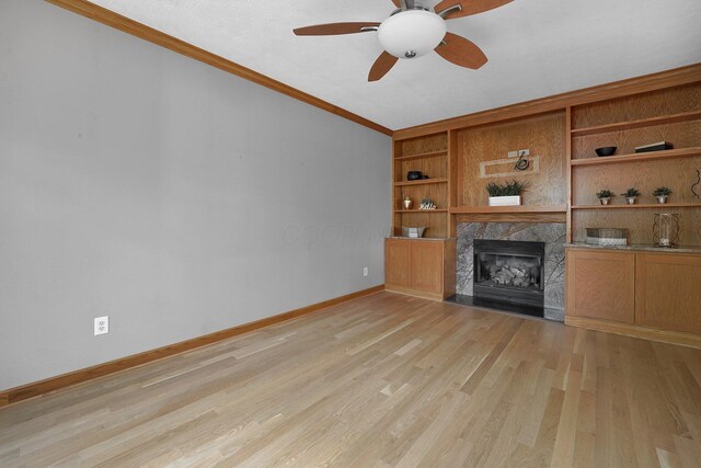 441 Gentlewind Dr, Westerville, OH 43081 - unfurnished living room with a ceiling fan, crown molding, baseboards, light wood-style flooring, and a premium fireplace