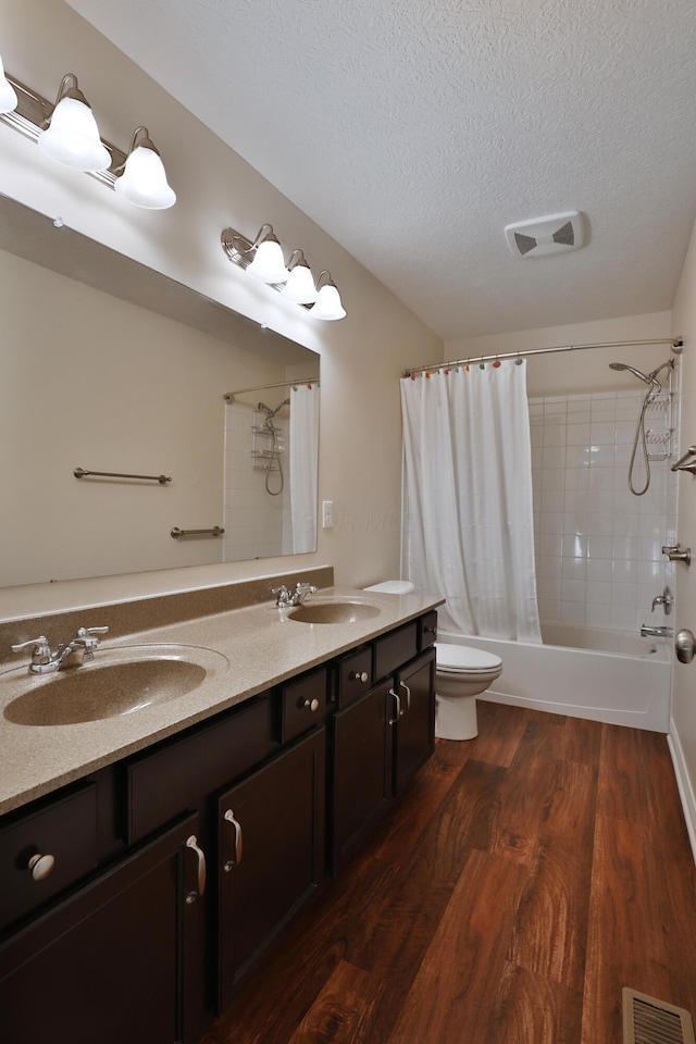 6134 Glade Run Rd, Hilliard, OH 43026 - bathroom with a textured ceiling, shower / bathtub combination with curtain, wood finished floors, toilet, and double vanity