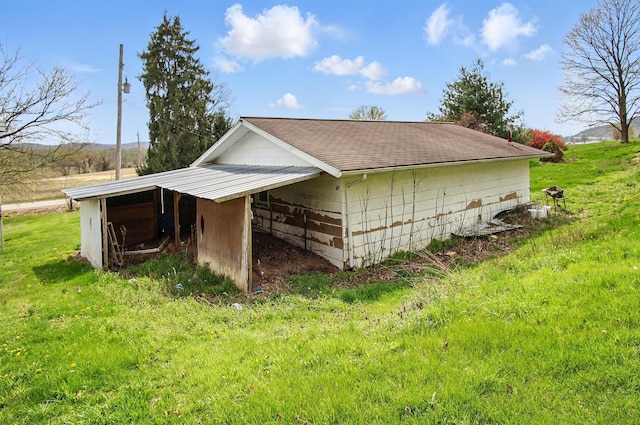 5235 Raiders Rd, Frazeysburg, OH 43822 - view of side of home with a lawn, a carport, roof with shingles, and an outbuilding