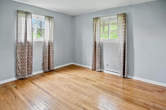 5235 Raiders Rd, Frazeysburg, OH 43822 - empty room with wood-type flooring, a baseboard radiator, and a healthy amount of sunlight