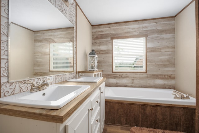 full bathroom featuring a garden tub, a sink, double vanity, and ornamental molding