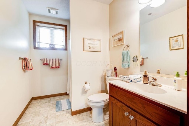bathroom featuring baseboards, visible vents, toilet, and vanity