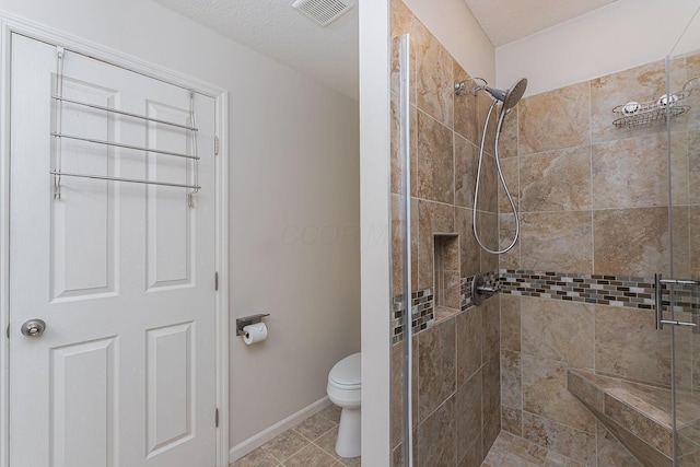 bathroom featuring baseboards, visible vents, toilet, and a stall shower