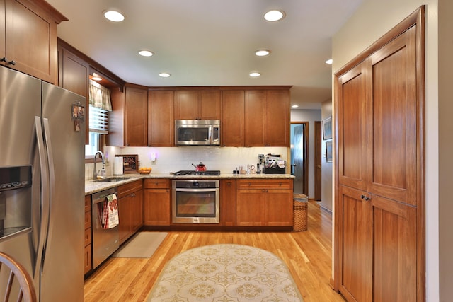 5580 Millington Rd, Columbus, OH 43235 - kitchen featuring light stone counters, a sink, stainless steel appliances, recessed lighting, and light wood finished floors