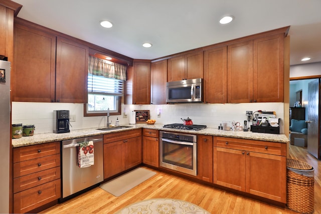 5580 Millington Rd, Columbus, OH 43235 - kitchen featuring decorative backsplash, a sink, stainless steel appliances, and light wood-style floors