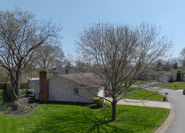 5580 Millington Rd, Columbus, OH 43235 - view of home's exterior with a garage, fence, a chimney, and a lawn