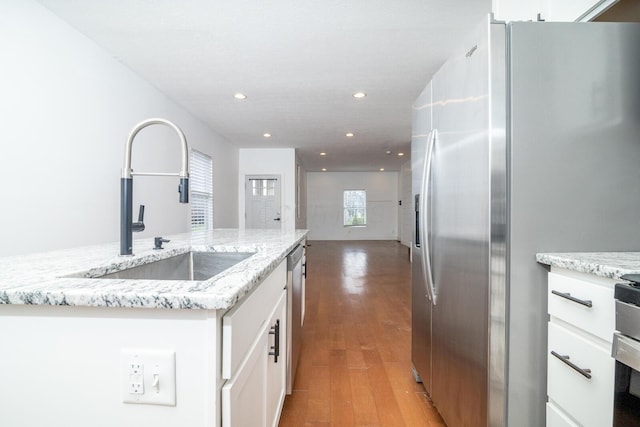 kitchen featuring recessed lighting, white cabinetry, stainless steel appliances, and a sink
