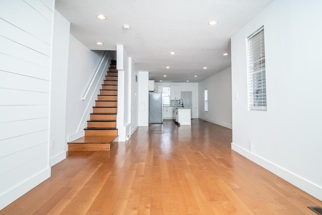 interior space featuring visible vents, baseboards, wood finished floors, and recessed lighting