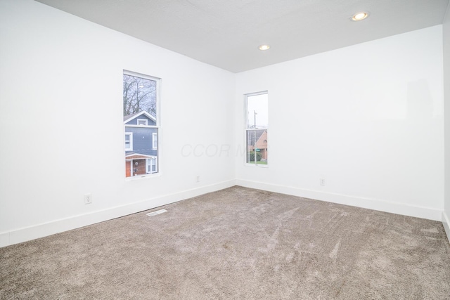 empty room featuring carpet flooring and baseboards