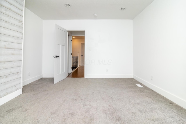 unfurnished room featuring baseboards and carpet