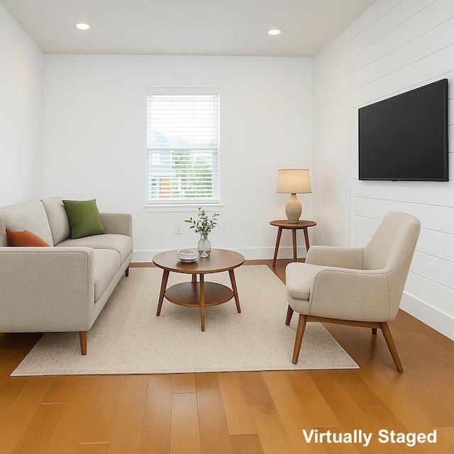 living area with baseboards, wood finished floors, and recessed lighting