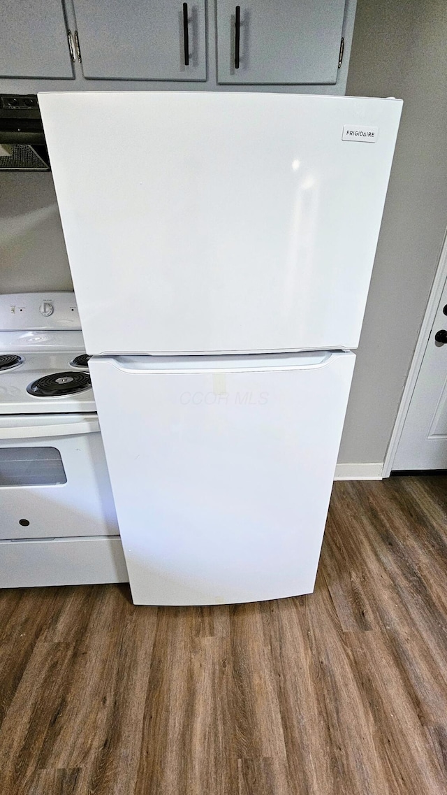 details featuring extractor fan, dark wood-style flooring, and white appliances