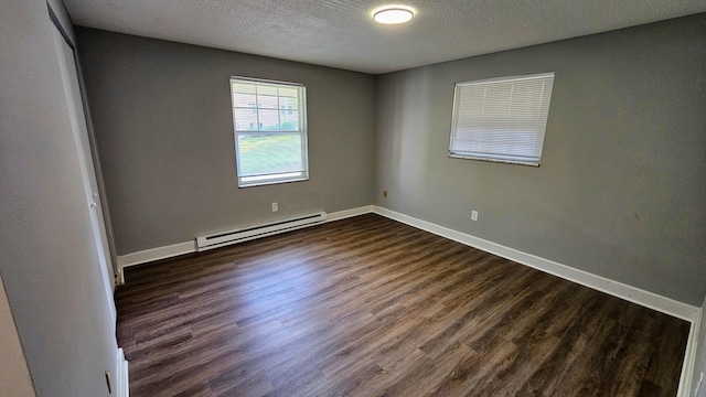 unfurnished room with dark wood finished floors, a baseboard heating unit, baseboards, and a textured ceiling