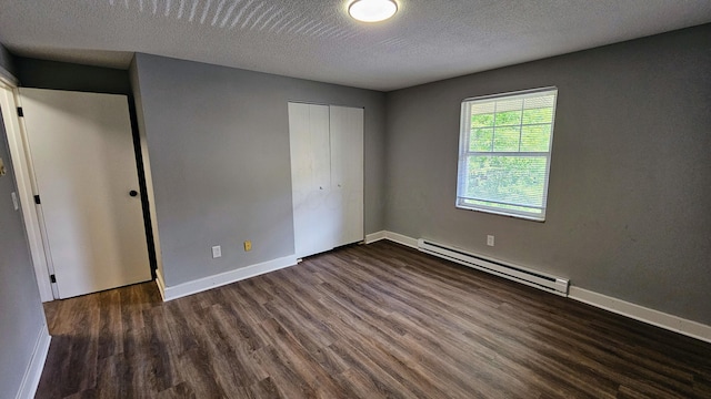 unfurnished bedroom with dark wood-type flooring, a baseboard radiator, a closet, and baseboards