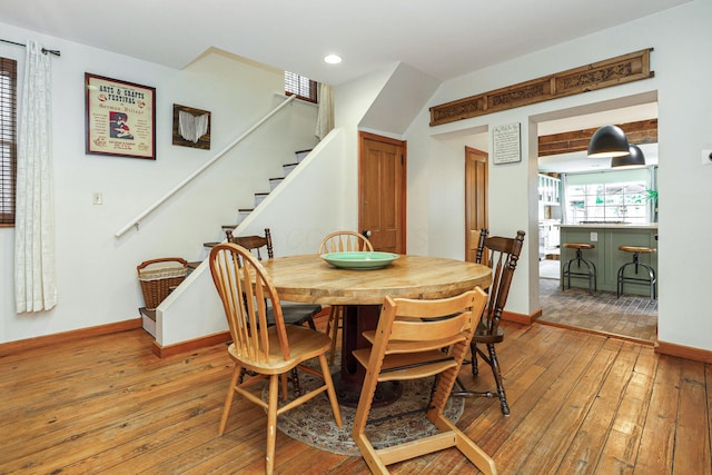 dining room with wood-type flooring, recessed lighting, stairs, and baseboards
