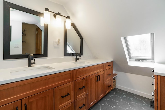 bathroom featuring double vanity, lofted ceiling, tile patterned flooring, and a sink