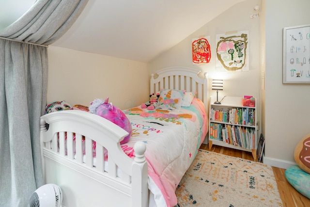 bedroom with lofted ceiling and wood finished floors