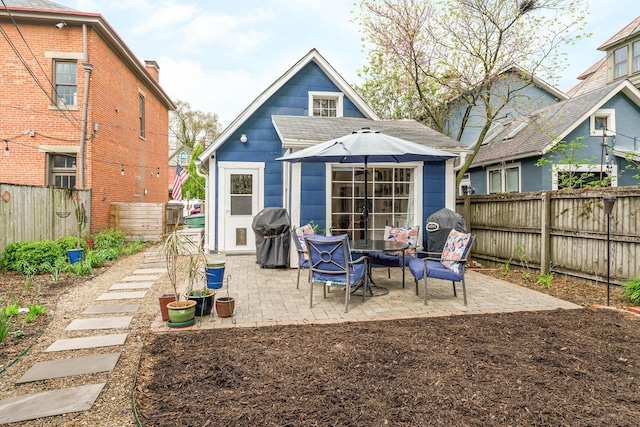 rear view of house featuring a fenced backyard and a patio area