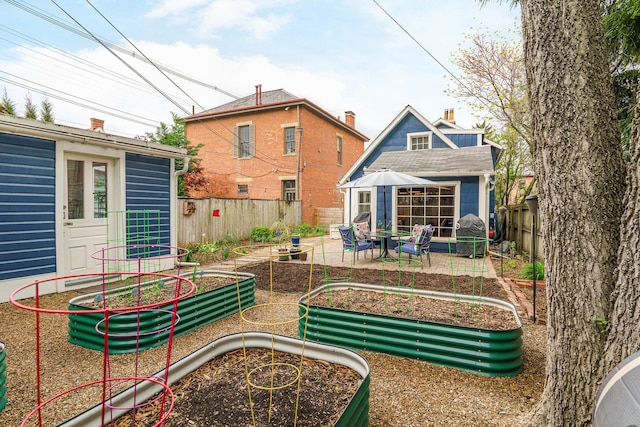 rear view of property with an outbuilding, a garden, a fenced backyard, and a chimney