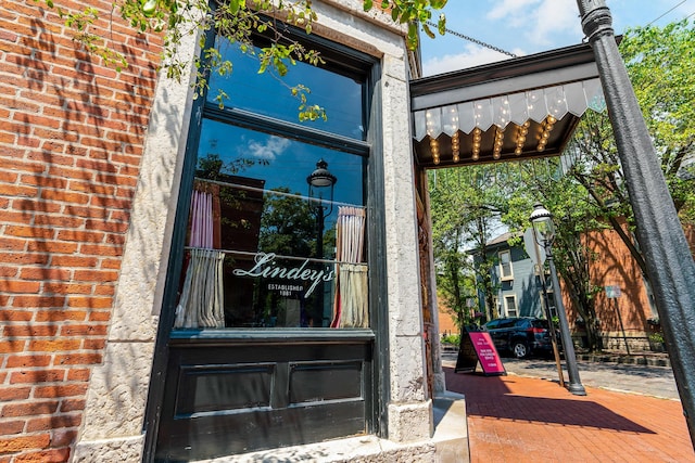 doorway to property featuring brick siding