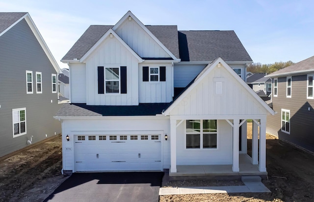 modern inspired farmhouse featuring board and batten siding, covered porch, aphalt driveway, a garage, and roof with shingles