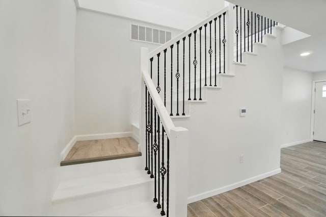 stairway featuring recessed lighting, visible vents, baseboards, and wood finished floors