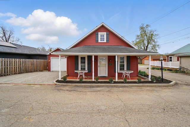view of front of property with driveway, a porch, fence, and a garage