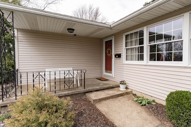 property entrance featuring a porch and fence