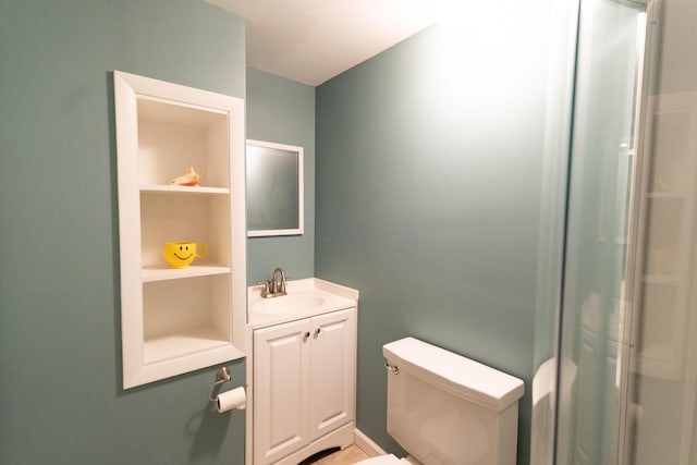 bathroom with built in features, toilet, and vanity