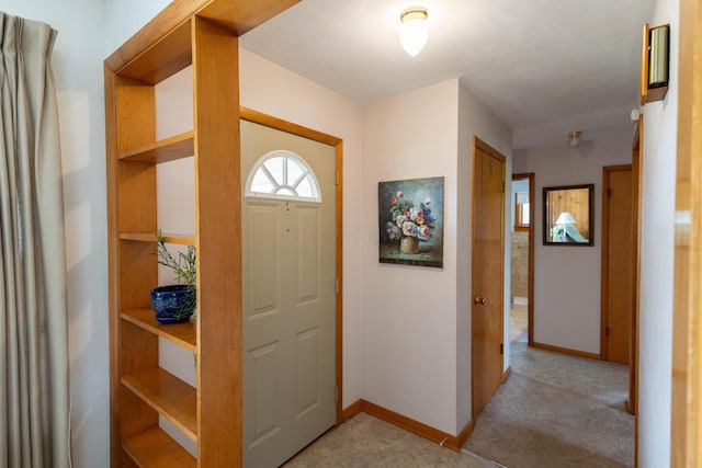 foyer with light carpet and baseboards